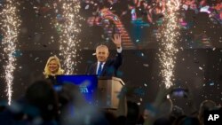 Israel's Prime Minister Benjamin Netanyahu, accompanied by his wife Sara, waves to his supporters after polls for Israel's general elections closed in Tel Aviv, Israel, April 10, 2019.