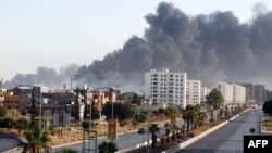 Une fumée noire se répand dans le ciel après l'incendie d'un dépôt pétrolier lors d'affrontements entre des milices rivales près de l'aéroport international de Tripoli, à la périphérie de la capitale, le 13 août 2014.
