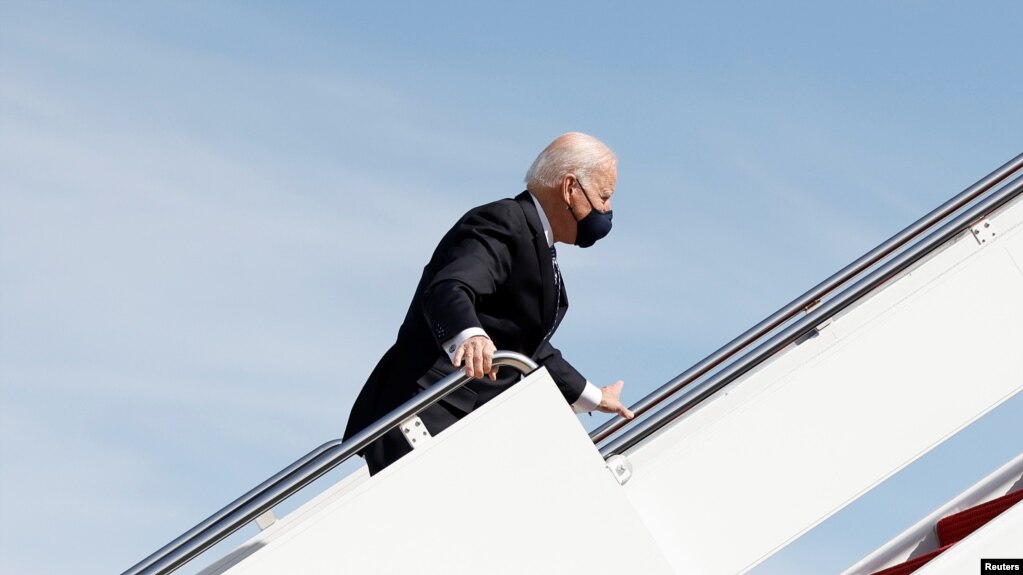 Tổng thống Mỹ Joe Biden nắm lấy tay vịn cầu thang sau khi ông vấp ngã trong khi leo lên chuyên cơ Air Force One rời Washington bay tới Atlanta, bang Georgia, tại Căn cứ Liên hợp Andrews, bang Maryland, ngày 19 tháng 3, 2021.