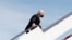 Tổng thống Mỹ Joe Biden nắm lấy tay vịn cầu thang sau khi ông vấp ngã trong khi leo lên chuyên cơ Air Force One rời Washington bay tới Atlanta, bang Georgia, tại Căn cứ Liên hợp Andrews, bang Maryland, ngày 19 tháng 3, 2021.