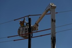 Pekerja memasak tiang listrik untuk saluran listrik setelah badai musim dingin yang tidak biasa di Texas.