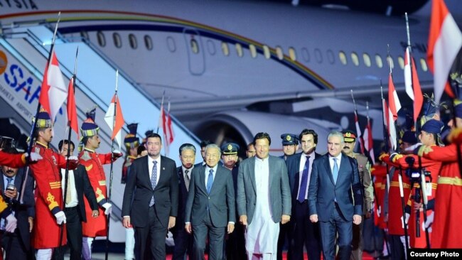 Prime Minister Imran Khan leads Malaysian Prime Minister Mahathir Mohamad and his entourage from their plane at the airport near Islamabad, March 21, 2019. (Photo courtesy of Pakistani prime minister's office)