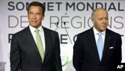 Former governor of California and founding chair of the R20 initiative, Arnold Schwarzenegger, left, and France's Foreign Minister Laurent Fabius, stand prior to making a speech at the World Summit of Regions for Climate, in Paris, Oct. 11, 2014.