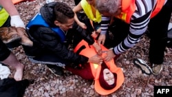 22일 터키 에게해를 건너 그리스 레스보스 섬에 도착한 난민 여성이 기절한 가운데 응급처치를 받고 있다.