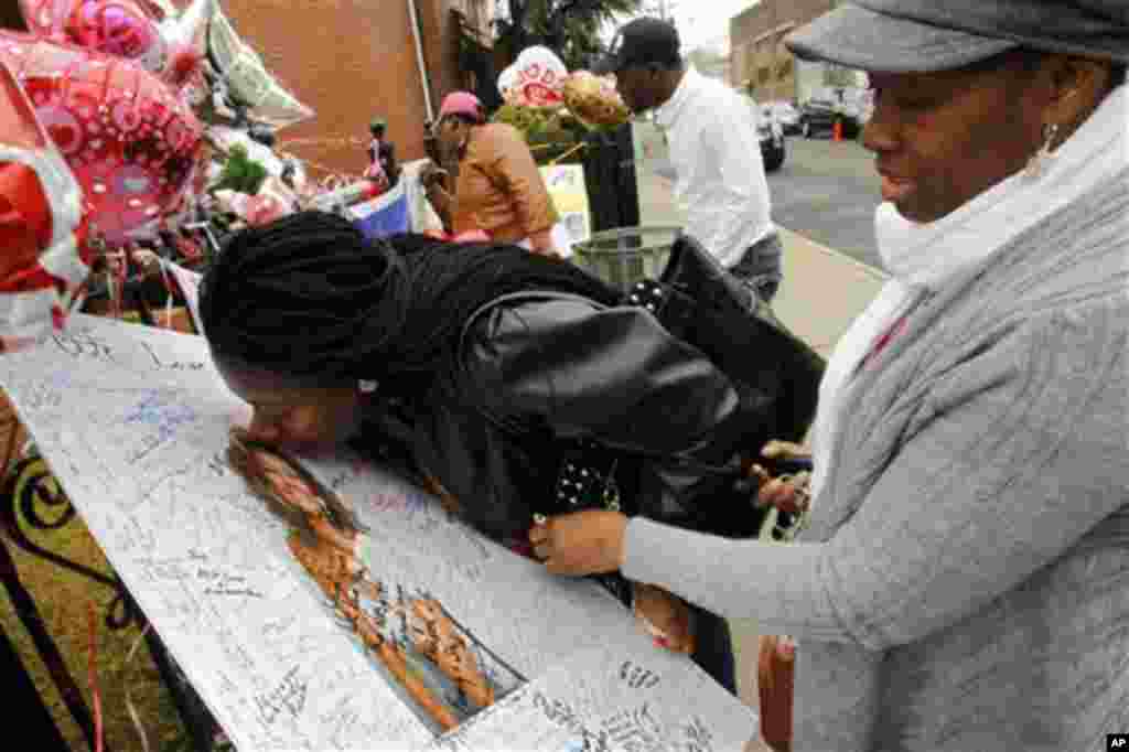 Yamda Johnson, kisses a signed photo of Whitney Houston as she and her friend Regina Kujemya both from Staten Island, N.Y., pay their respects at New Hope Baptist Church, in Newark, N.J., Wednesday, Feb. 15, 2012.