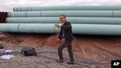President Barack Obama waves as he arrives at the TransCanada Stillwater Pipe Yard in Cushing, Oklahoma, March, 22, 2012.
