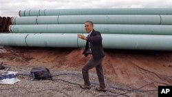 President Barack Obama waves as he arrives at the TransCanada Stillwater Pipe Yard in Cushing, Oklahoma, March, 22, 2012.
