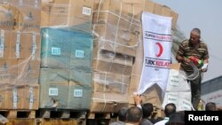 Palestinians unload Turkish aid shipments upon arrival in the Gaza Strip at Kerem Shalom crossing between Israel and southern Gaza Strip, July 4, 2016.