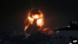 An explosion caused by Israeli airstrikes is seen from the offices of Hamas leader Ismail Haniyeh, in Gaza City, March 25, 2019.