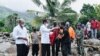 Presiden Joko Widodo (tengah) memberikan jaketnya kepada seorang korban saat memeriksa kerusakan di Pulau Lembata akibat hujan lebat dari Siklon Tropis Seroja, 9 April 2021. (Istana Presiden RI/AFP)
