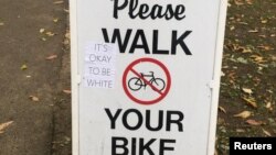 A sign reading "It's okay to be white" is attached to a billboard in Cambridge, Massachusetts, U.S., Nov. 1, 2018, in this picture obtained from social media.