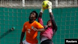 Fabrice Ondoa gardien du Cameroun, à droite, subtilise une balle de la tête de Wilfried Bony de la Côte d'Ivoire lors du match de qualification pour la Coupe d'Afrique des Nations au stade Felix Houphouet Boigny à Abidjan, 19 novembre 2014. 