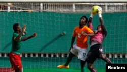 Fabrice Ondoa gardien du Cameroun, à droite, subtilise une balle de la tête de Wilfried Bony de la Côte d'Ivoire lors du match de qualification pour la Coupe d'Afrique des Nations au stade Felix Houphouet Boigny à Abidjan, 19 novembre 2014.