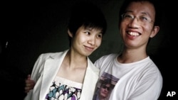 In this July 6, 2007 file photo, Hu Jia, right, and Zeng Jinyan, husband-and-wife activists, pose for a picture at their home in Beijing. Zeng said she visited Hu, who was jailed for sedition more than three years ago, in prison June 20, 2011. Jia was rel