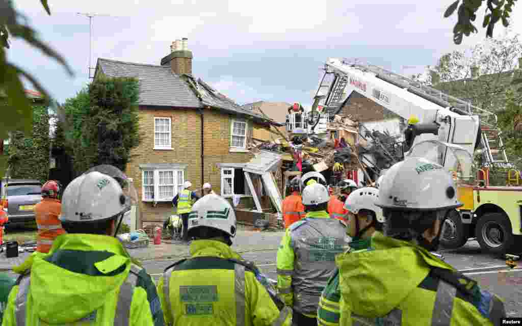 Petugas layanan darurat membereskan kerusakan akibat pohon tumbang di Hounslow, sebelah barat London (28/10).