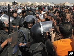 Anti-Mubarak protesters scuffle with riot police outside the Police Military Academy complex in Cairo, Egypt, August 3, 2011, during the trial session of ousted President Hosni Mubarak