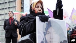 An Iranian demonstrator holds a picture of Sakineh Mohammadi Ashtiani as she protests in front of the EU Council in Brussels. About 50 protestors asked for action from the EU to save Ashtiani from being stoned to death in Iran, 3 Nov 2010.