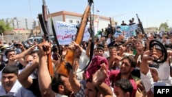 Iraqi men raise up weapons and shout slogans as they demonstration in the central Shiite Muslim shrine city of Najaf on June 14, 2014 to show their support for the call to arms by Shiite cleric Grand Ayatollah Ali al-Sistani. 