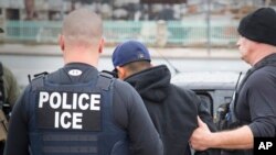 FILE - U.S. Immigration and Customs Enforcement (ICE) agents arrest foreign nationals, Feb. 7, 2017, in Los Angeles. Under the Trump administration, ICE has been directed to pursue deportations aggressively, with a particularly strong focus on Cambodians.