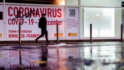 A woman walks past an abandoned coronavirus test center in Frankfurt, Nov. 2, 2021. Numbers of coronavirus infections are rising again in Germany.