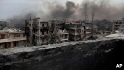 FILE - Smoke rises over Saif Al Dawla district, in Aleppo, Syria. 