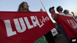 Supporters of Brazil's former President Luiz Inacio Lula da Silva, display banners saying "Free Lula" in Portuguese during a protest in front of the Superior Electoral Court, Brasilia, Aug. 31, 2018.