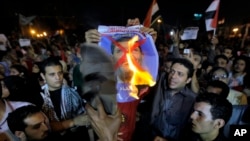 Anti-government protesters burn a post of President Morsi in Tahrir Square, Cairo, June 26, 2013.