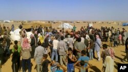 People gather for a food aid distribution at Rukban refugee camp on the Jordan-Syria border, Aug. 4, 2016. The camp is home to some 50,000 Syrians.