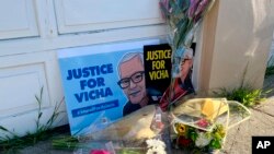 Flowers are left with a picture of 84-year-old Vicha Ratanapakdee, as hundreds of people hold a rally Sunday, Jan. 30, 2022, in San Francisco and five other U.S. cities to remember the death of 84-year-old Vicha Ratanapakdee. The grandfather from Thailand was assaulted while on a morning walk a year ago in his San Francisco neighborhood and died two days later, never regaining consciousness. (AP Photo/Janie Har)