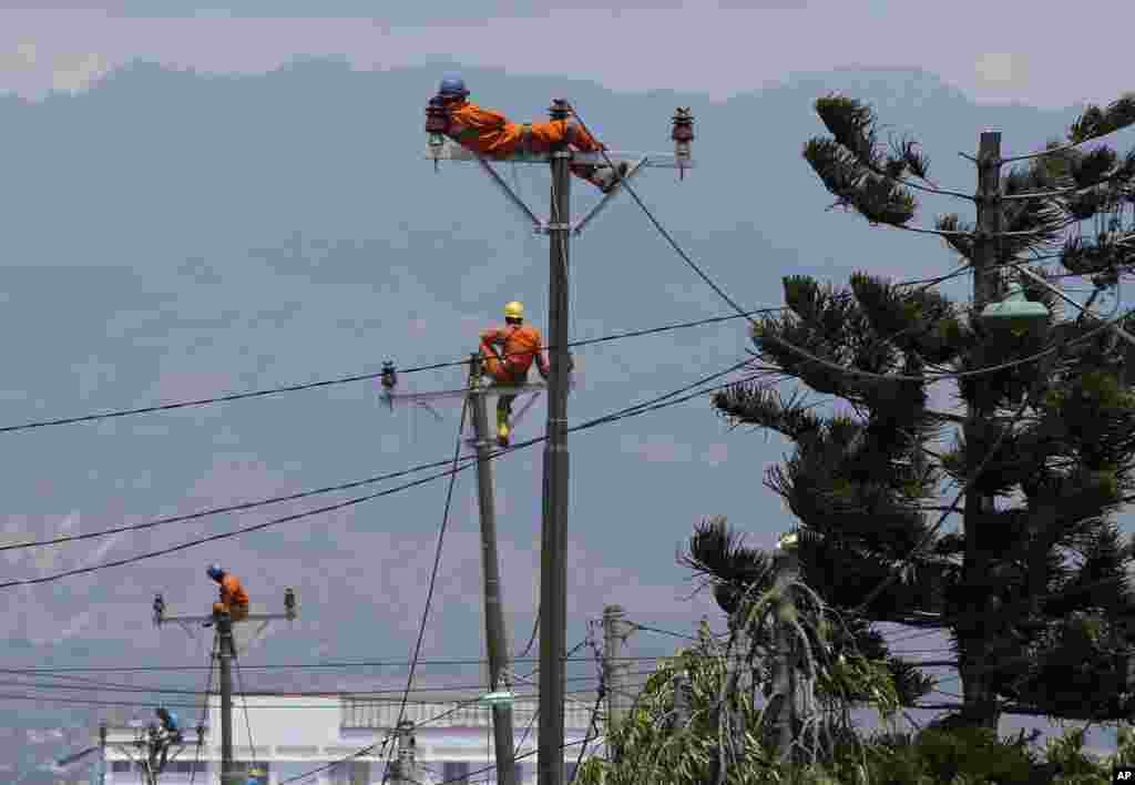 A worker rests on top of a pole as they restore electricity at the earthquake-hit Balaroa neighborhood in Palu, Central Sulawesi, Indonesia, Oct. 6, 2018.