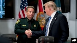 Predsednik Tramp rukuje se sa šerifom okruga Brauard Skotom Izraelom 16. februara 2018. za vreme susreta sa pripadnicima policije na Floridi posle masakra u školi Mardžori Stounmen Daglas.