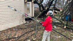 Chris Chiles, disaster response coordinator for Virginia-based God's Pit Crew, works a chainsaw on a fallen tree outside a home in the aftermath of a tornado in Mayfield, Ky., Dec. 16, 2021.