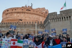 People gather during a twilight vigil prayer of the victims of sex abuse near Castle Sant' Angelo, in Rome, Feb. 21, 2019.