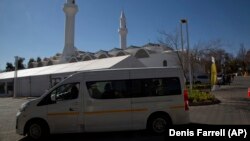 Un véhicule minibus arrive à la mosquée Houghton, qui sert de centre de vaccination COVID-19 au volant à Johannesburg, le 28 juillet 2021.