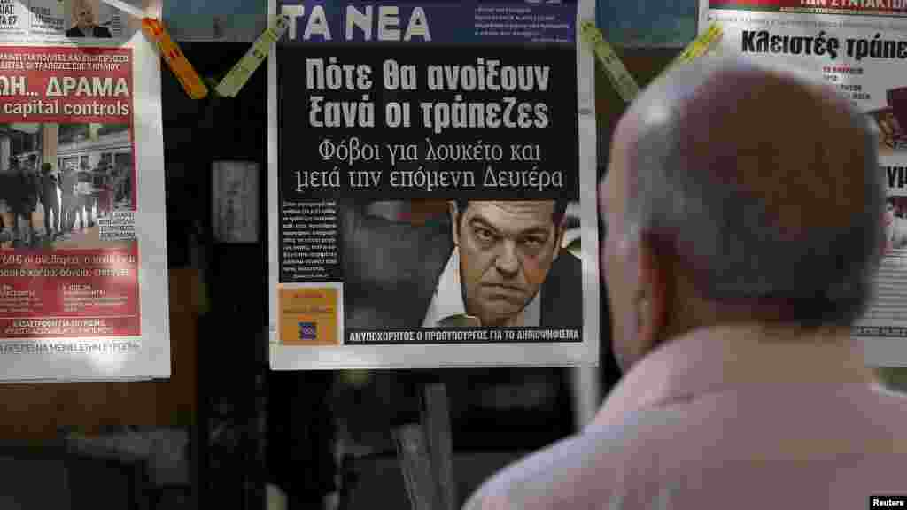 Người dân Hy Lạp đọc tin tức về vụ khủng hoảng tài chính tại một sạp bán báo ở Athens, ngày 29/6/2014.
