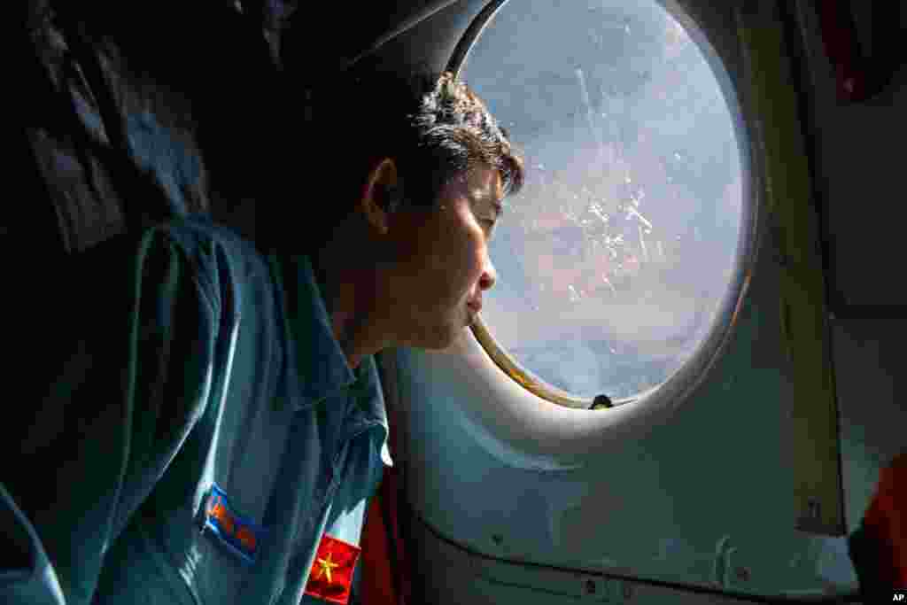 Một sĩ quan của Không quân Việt Nam nhìn ra cửa sổ trên máy bay AN-26 trong hoạt động tìm kiếm chiếc máy bay Malaysia bị mất tích trên biển phía nam giữa Việt Nam và Malaysia, ngày 14/3/2014.