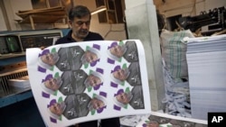 Kianoush Mahmoudzadeh prepares electoral posters of President Hassan Rouhani for the May 19 presidential election campaign in a printing house in Tehran, Iran, May 10, 2017.