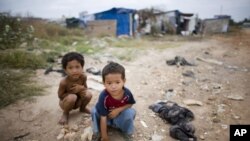 Two young Cambodian boys play near their slum home on the outskirts of Phnom Penh. 