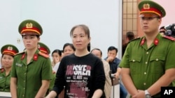 FILE - Nguyen Ngoc Nhu Quynh, center, a prominent Vietnamese blogger, stands trial in the south-central province of Khanh Hoa, Vietnam. 