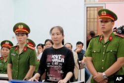 FILE - Nguyen Ngoc Nhu Quynh, center, stands trial in the south-central province of Khanh Hoa, Vietnam.