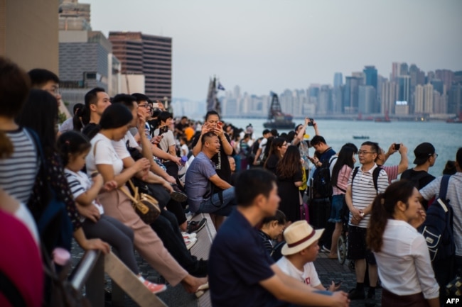 Tourists visit a Kowloon promenade along Victoria Harbor in Hong Kong, Oct. 3, 2018, during China's "Golden Week" holiday that runs from Oct. 1 to 7.