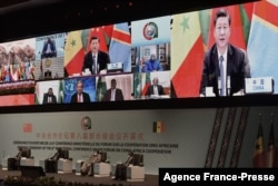 FILE - Chinese President Xi Jinping (on screen) delivers his speech during the China-Africa Cooperation (FOCAC) meeting in Dakar, Senegal, on November 29, 2021.