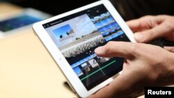A member of the media holds the new iPad mini with Retnia display during an Apple event in San Francisco, California, Oct. 22, 2013. 
