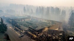 Smoke hangs over the scorched remains of Old Town Plaza following the wildfire in Paradise, Calif., Nov. 15, 2018. The shopping center housed a grocery store and other businesses.