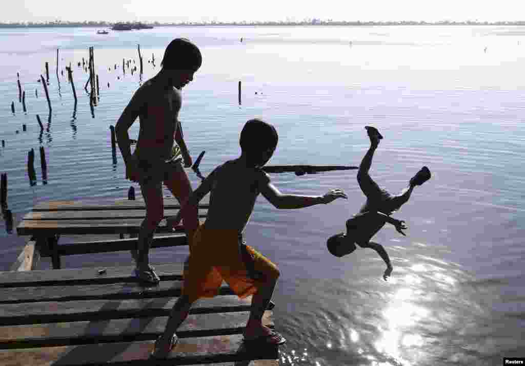 Boys jump from a cut-off foot bridge, which was damaged by Typhoon Haiyan, in Tacloban City in central Philippines. Almost 25,000 people still live in tents, shelters and bunkhouses in the hardest hit regions. The Philippines are preparing to commemorate