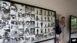 A tourist walks past photos of former prisoners displayed at Tuol Sleng genocide museum, a former Khmer Rouge prison known as S-21, in Phnom Penh.