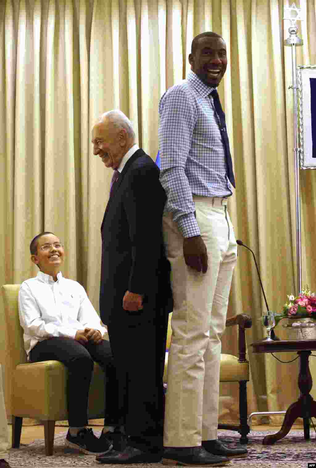 Israeli President Shimon Peres stands back to back with NBA basketball player Amar&#39;e Stoudemire of the New York Knicks at the presidential residency in Jerusalem. 