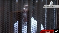Video menunjukkan mantan Presiden Morsi berteriak-teriak ke arah hakim dari kurungan yang kedap suara (28/1).