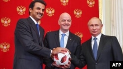 L'Emir du Qatar, le cheikh Tamim bin Hamad Al-Thani, le président de la FIFA Gianni Infantino et le président russe Vladimir Poutine posent pour une photo lors du transfert symbolique de l'autorité au Qatar pour accueillir la Coupe du monde 2022 au Kremlin de Moscou, le 15 juillet 2018.