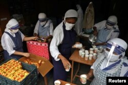 FILE - Catholic nuns from the Missionaries of Charity, the global order of nuns founded by Saint Mother Teresa, prepare to distribute free snacks and tea among the poor, in Kolkata, India, Aug. 26, 2021.